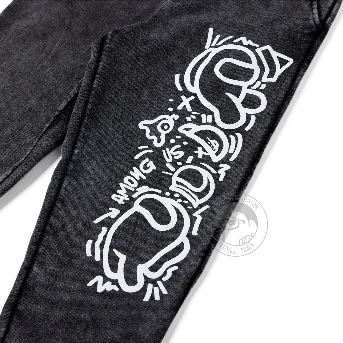 A flat lay product photograph of the front of the joggers at a ¾ angle tilting left. This image shows a close up of the front right pant leg screenprint detail.