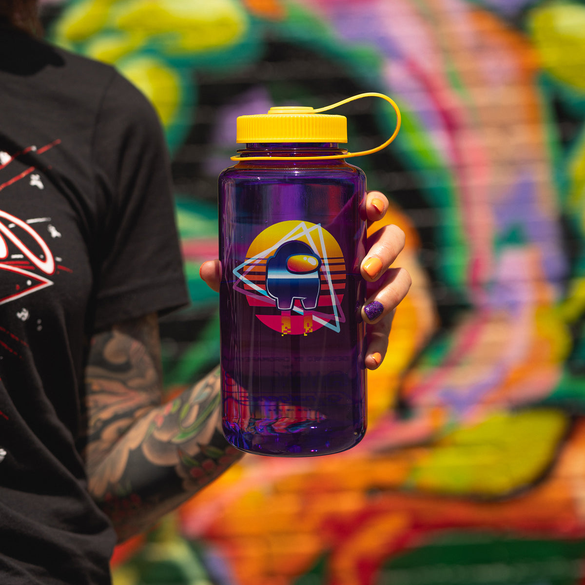 A model holding the Crewmate water bottle in front of a graffiti wall.