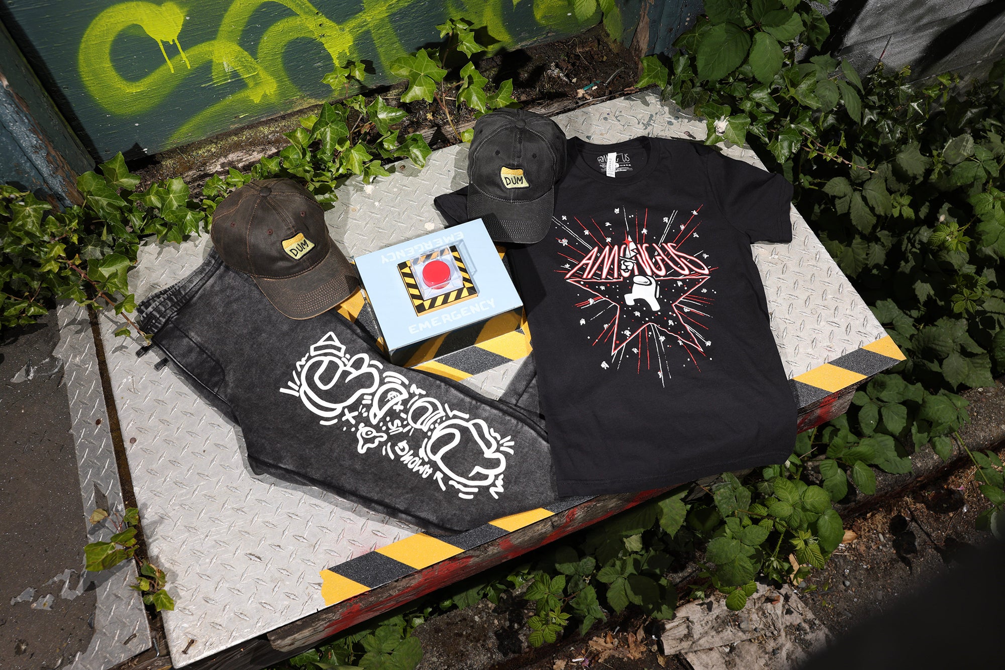 Photograph showcasing some of the Among Us: 5th Anniversary Collection, including printed tee, cap, joggers, and the collector’s edition of the game.