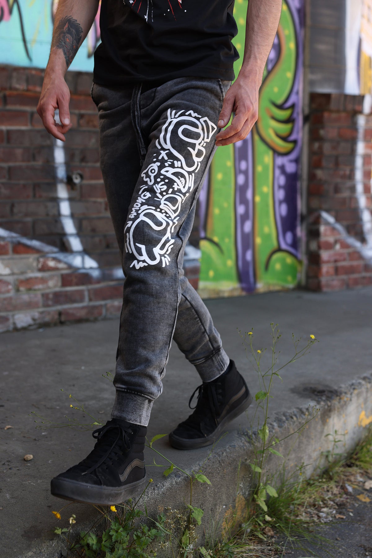  A photograph of a model in a ¾ view walking, their left leg showing off the screenprint is in front of them. 
