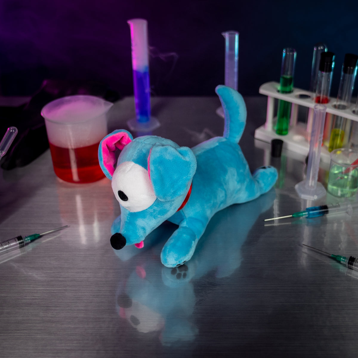  An Among Us: Doggy plush on a metal table surrounded by beakers, test tubes, and syringes filled with colorful liquids.