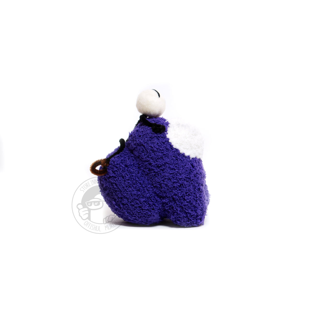A right-facing profile product photograph of the Purple Crewmate plush with the tiny needle felted and pipe cleaner Henry Stickmin figure on top of its head. From this angle you can see the Crewmate’s big, round, and thick backpack in full view.