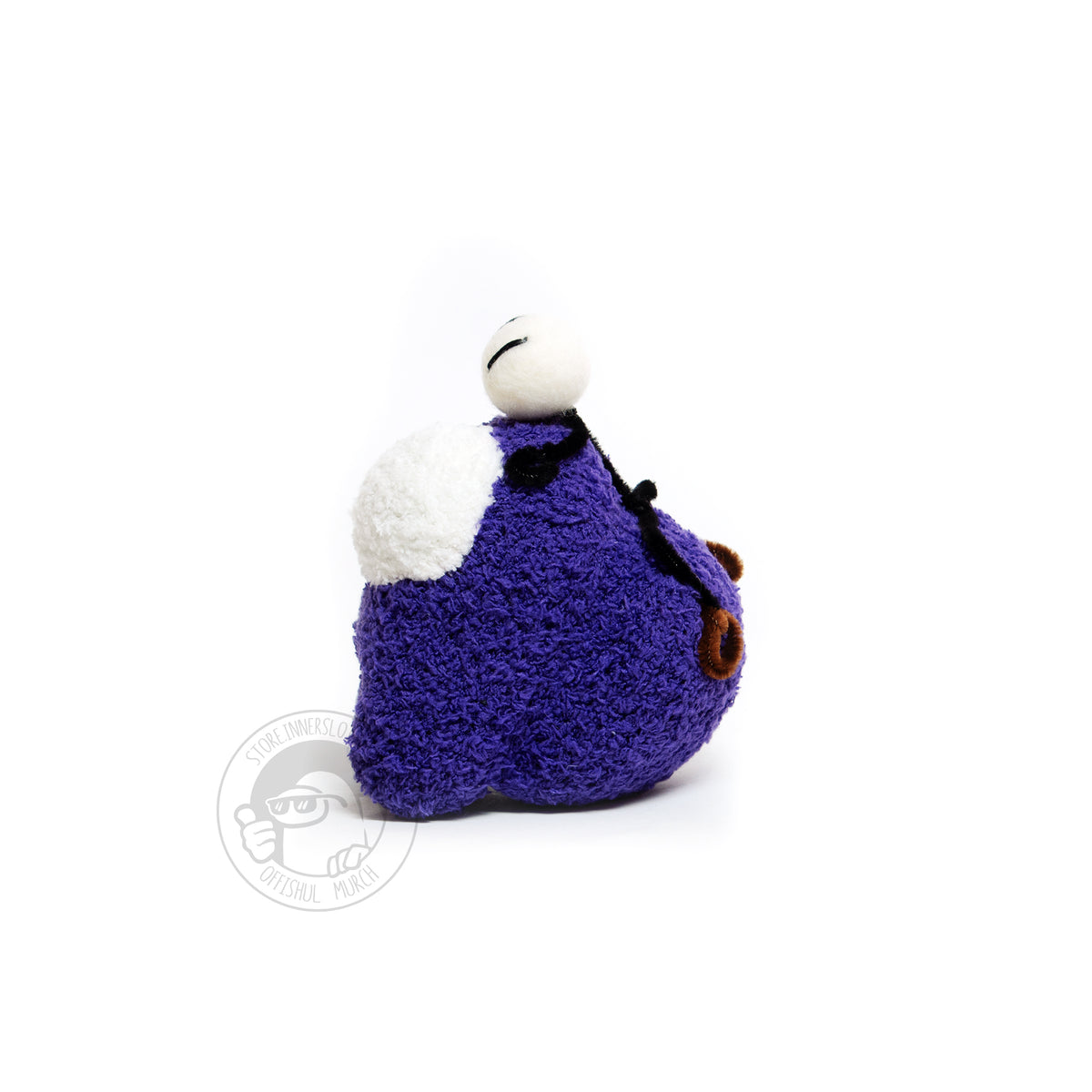 A left-facing profile product photograph of the Purple Crewmate plush with the tiny needle felted and pipe cleaner Henry Stickmin figure on top of its head. From this angle you can see the Crewmate’s big, round, and thick backpack in full view.