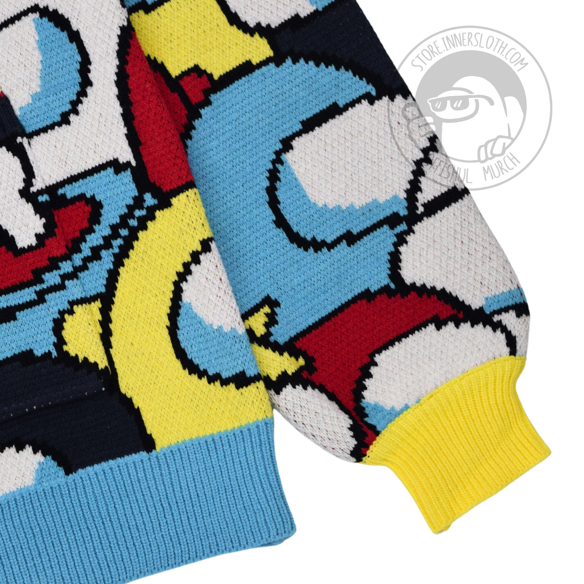 A close up section of the lower right side of the cardigan, emphazing a small piece of the AOP, a chunky bright yellow cuffed sleeve and chunky sky blue bottom trim.