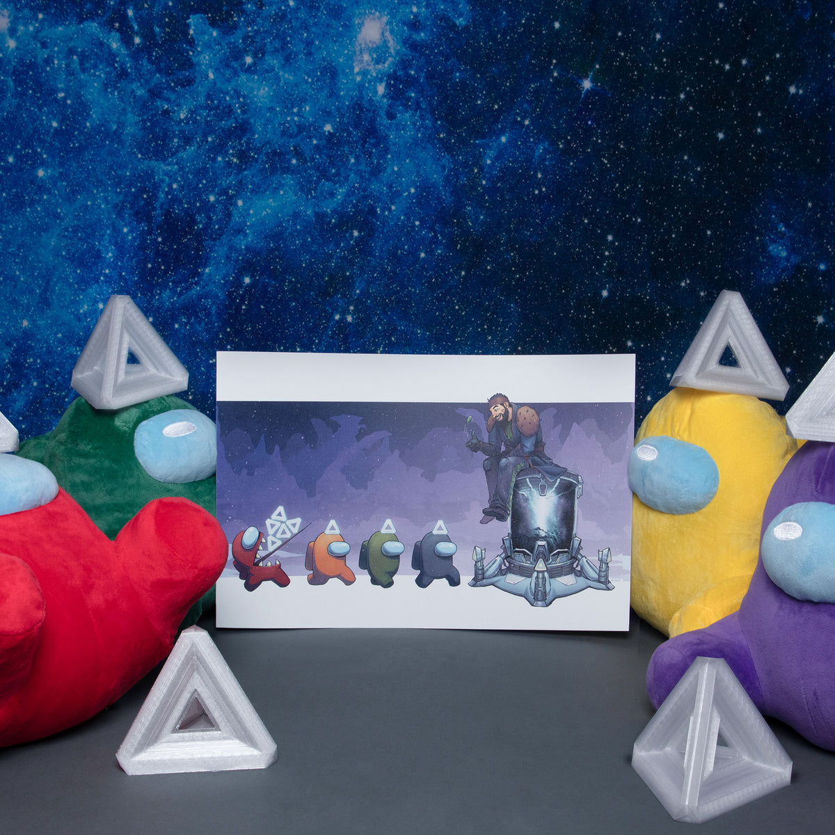 Four Crewmate Plushies wearing triangular 3D printed motes sit against a starry, blue, galaxy background. Two plush Crewmates, red and green on the left and yellow and purple on the right, frame the Bank the Motes Task print on either side. Two 3D printed motes can be seen in the foreground on either side.