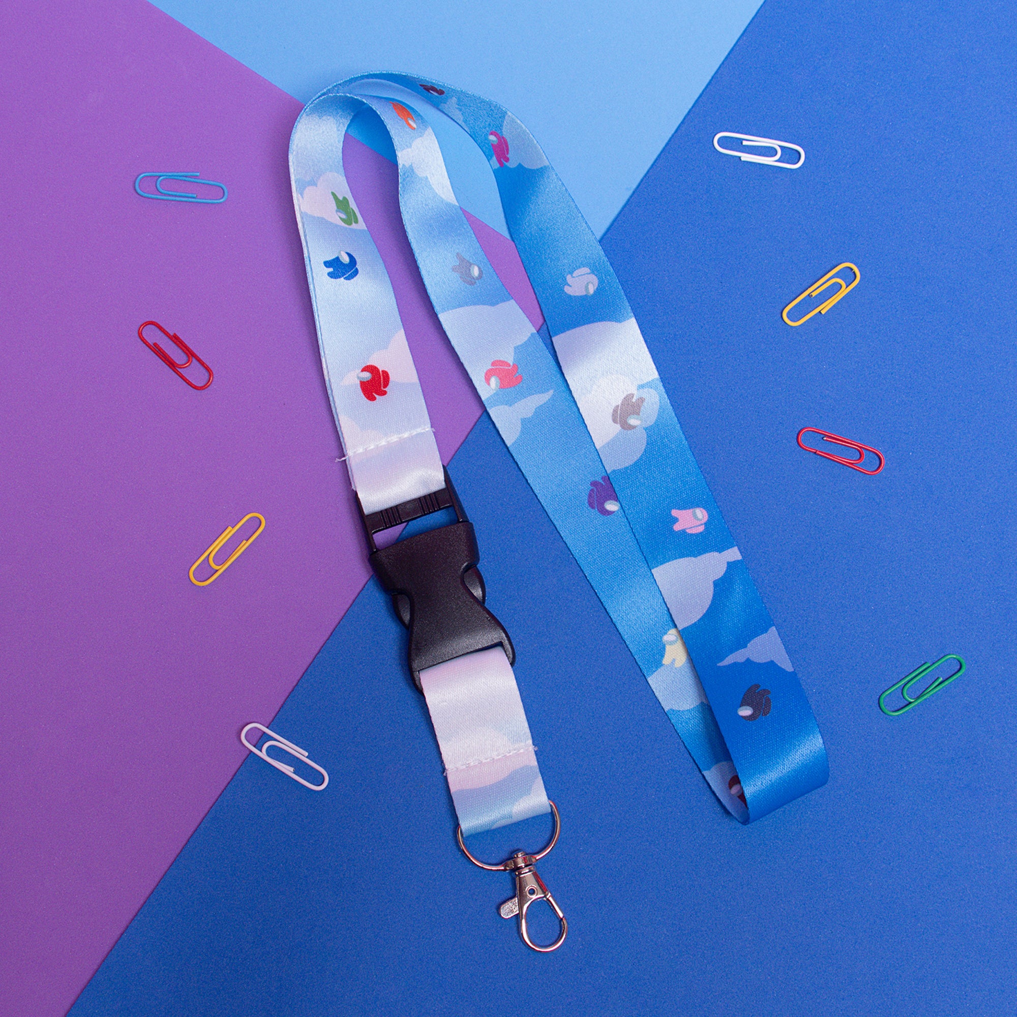 A lanyard with a sky on it and multi-colored crewmates on a white background.