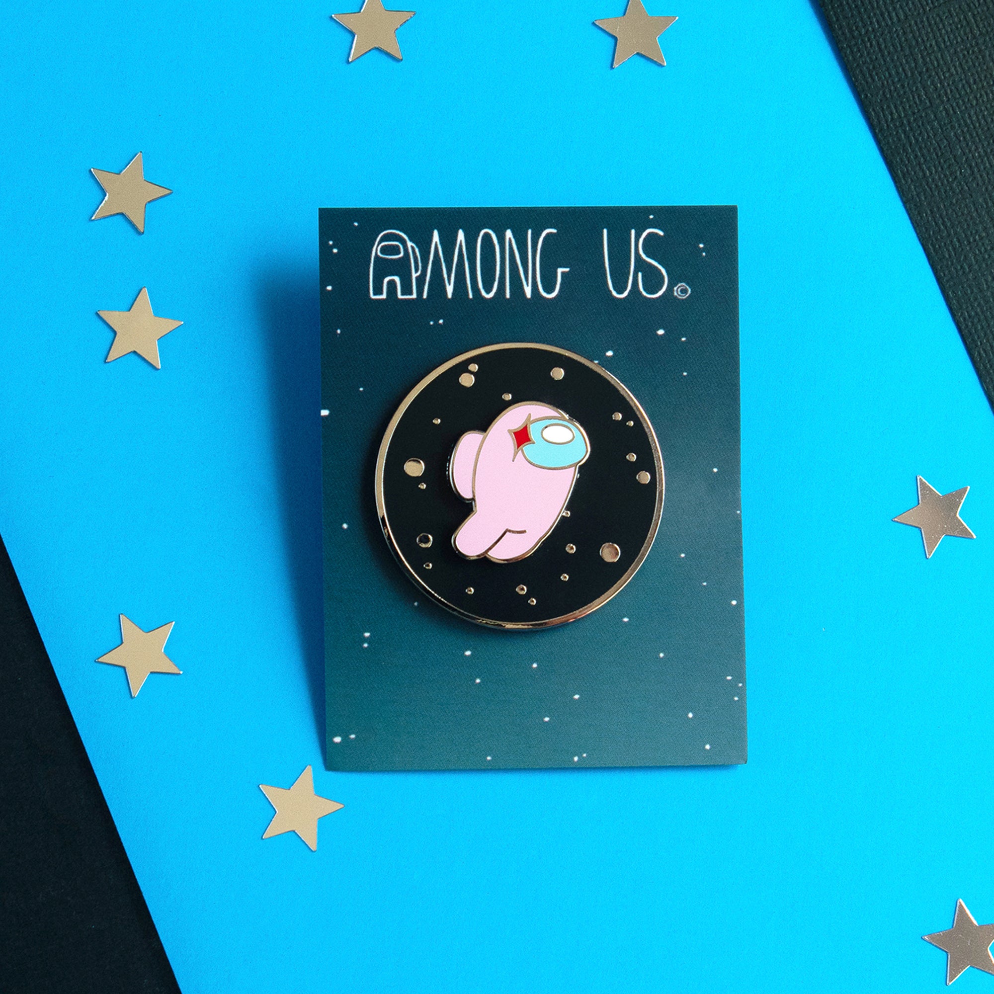 An enamel pin with the Rose crewmate on a space background. 