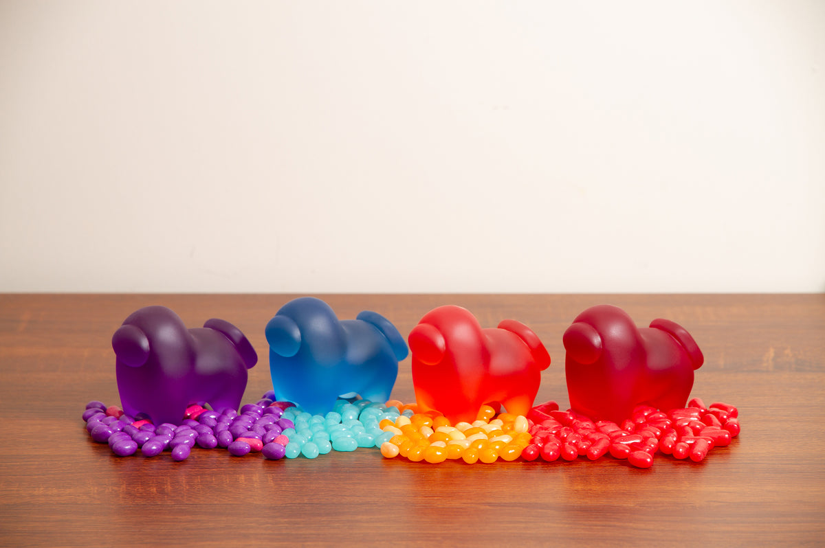 An overhead photograph of the Four Horse-shaped Crewmate figurines standing on top of jellybeans that match their respective colors.