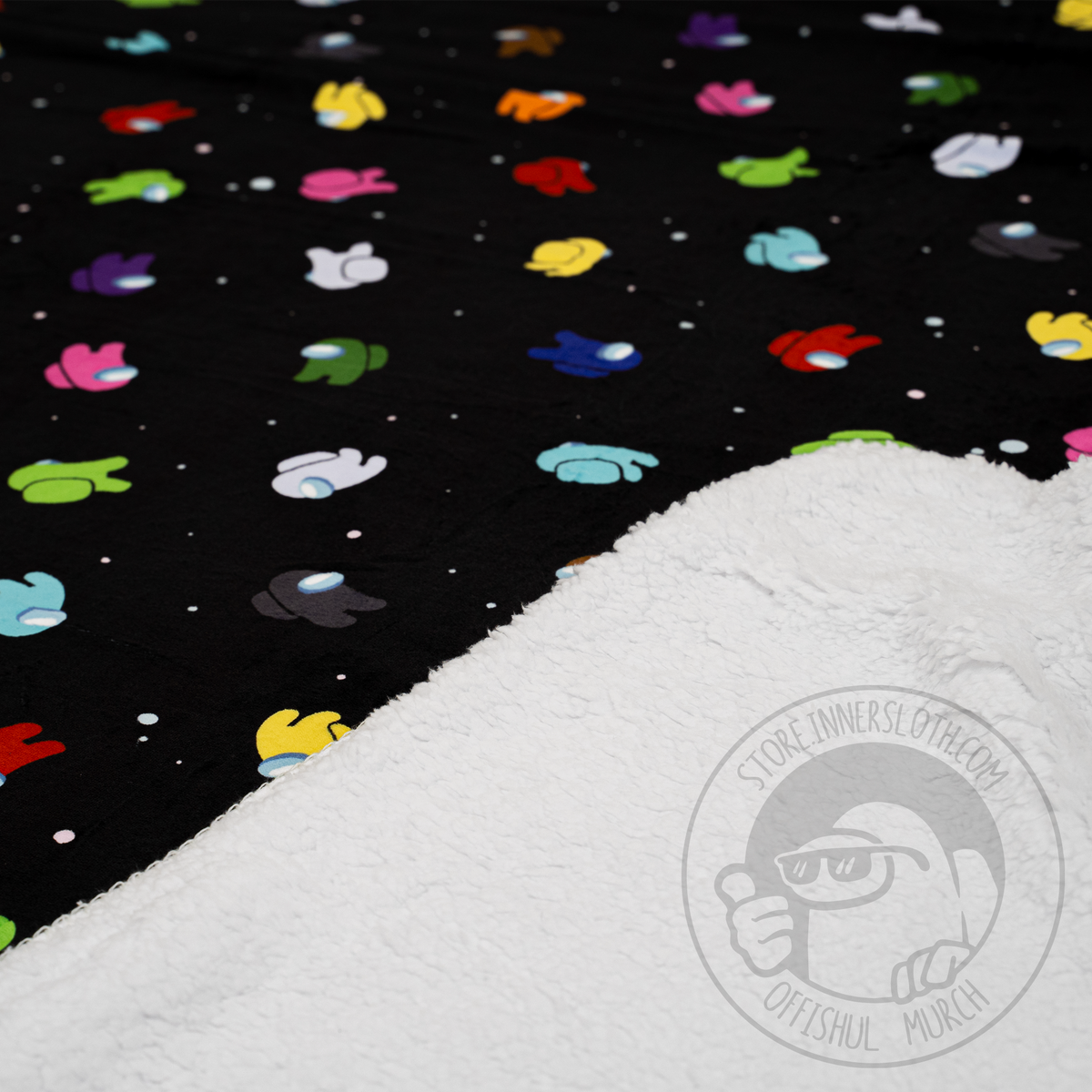 An angled shot of the blanket, folded partially, shows off the inner sherpa-lining and outer &quot;Space Party&quot; pattern.